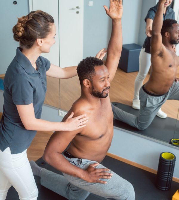 Young black man receiving physical therapy after sport injury